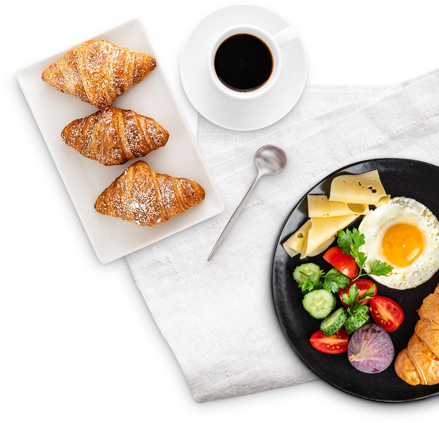 Frühstück mit Croissants, Ei, Käse, Gemüse und Kaffee